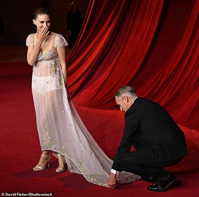 Joaquin Phoenix's, 49, wife Rooney Mara, 39, blushed as he fixed her dress on the red carpet of the Academy Museum Gala in LA on Saturday