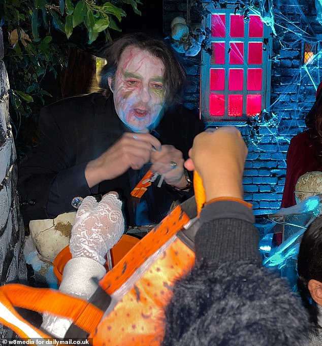 Jonathan Ross was spotted at his home in Hampstead, London, on Thursday evening putting on a creepy show for tricking children