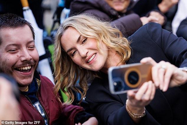 The Oscar-winning actress, 49, looked cheerful as she stopped to pose for selfies with fans outside the theater