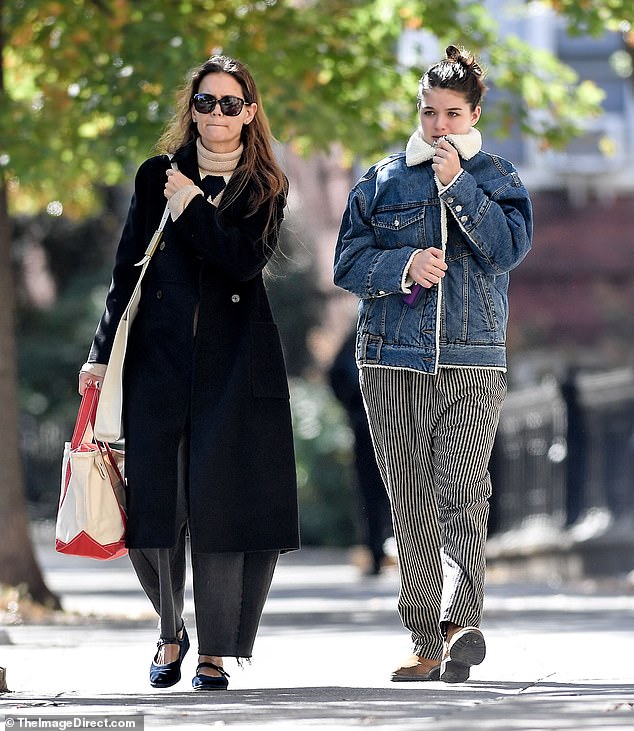 Katie looked chic in a geometric print jumper and black jacket, teamed with gray trousers and ballet flats