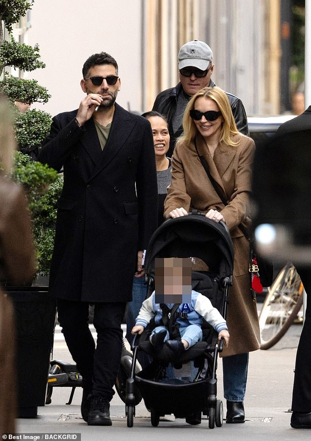 Lindsay Lohan looked effortlessly chic in a brown trench coat as she enjoyed a family walk in Paris with her husband Bader Shammas and son Luai on Tuesday