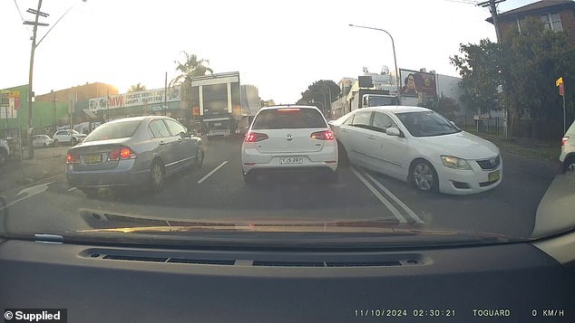 Dashcam vision obtained by Daily Mail Australia shows a white sedan driving a truck at high speed through an intersection on Parramatta Road near Granville in the city's west about 6.45pm on Friday