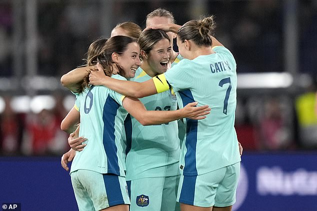 Kyra Cooney-Cross (centre) is mobbed by her teammates after scoring a special goal from about 40 yards out to level the scores in Germany