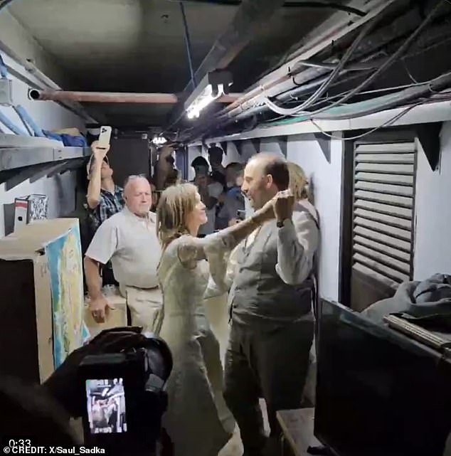 The touching scene showed the couple slowly dancing in the cramped and dusty hideaway as their wedding guests looked on and filmed the romantic moment.