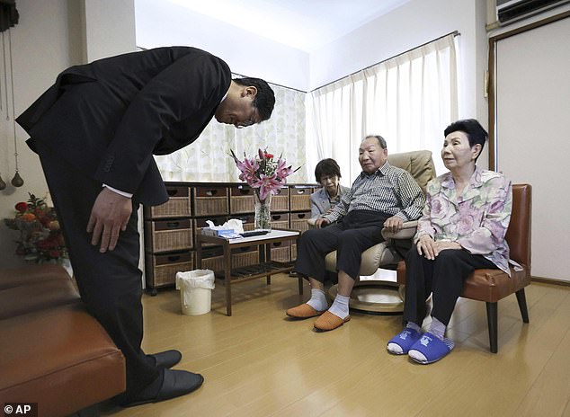 Takayoshi Tsuda, left, apologizes to former Japanese death row inmate Iwao Hakamada