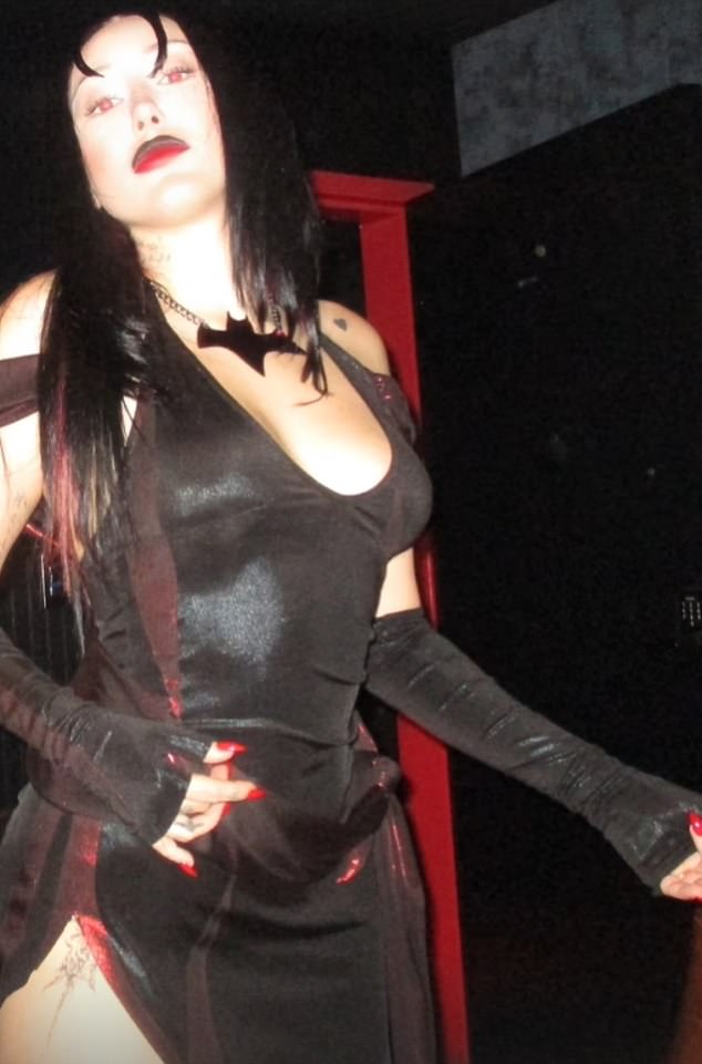 She emphasized her curves in a figure-hugging black slit dress with dull red accents, paired with fingerless opera gloves to show off her blood-red nail polish