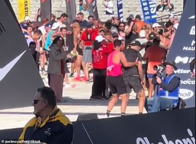 Champion Aussie runner Julian Spence (in the pink top) interrupted his finish to help a struggling racer