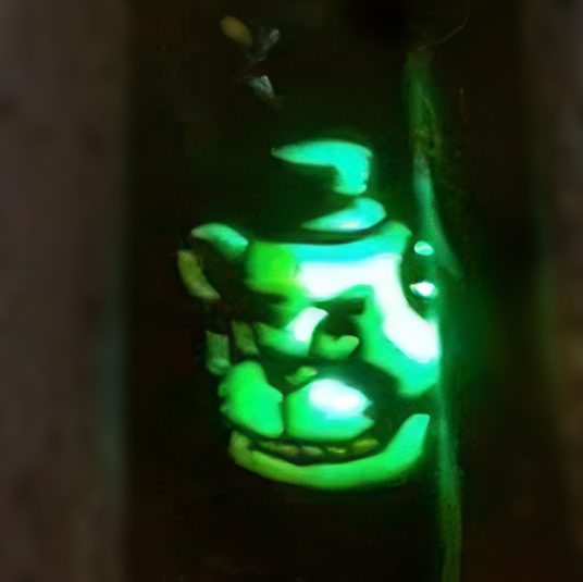 A pumpkin with a carved face of a sinister mascot bear and a hat. The bear is illuminated with a blue-green light.