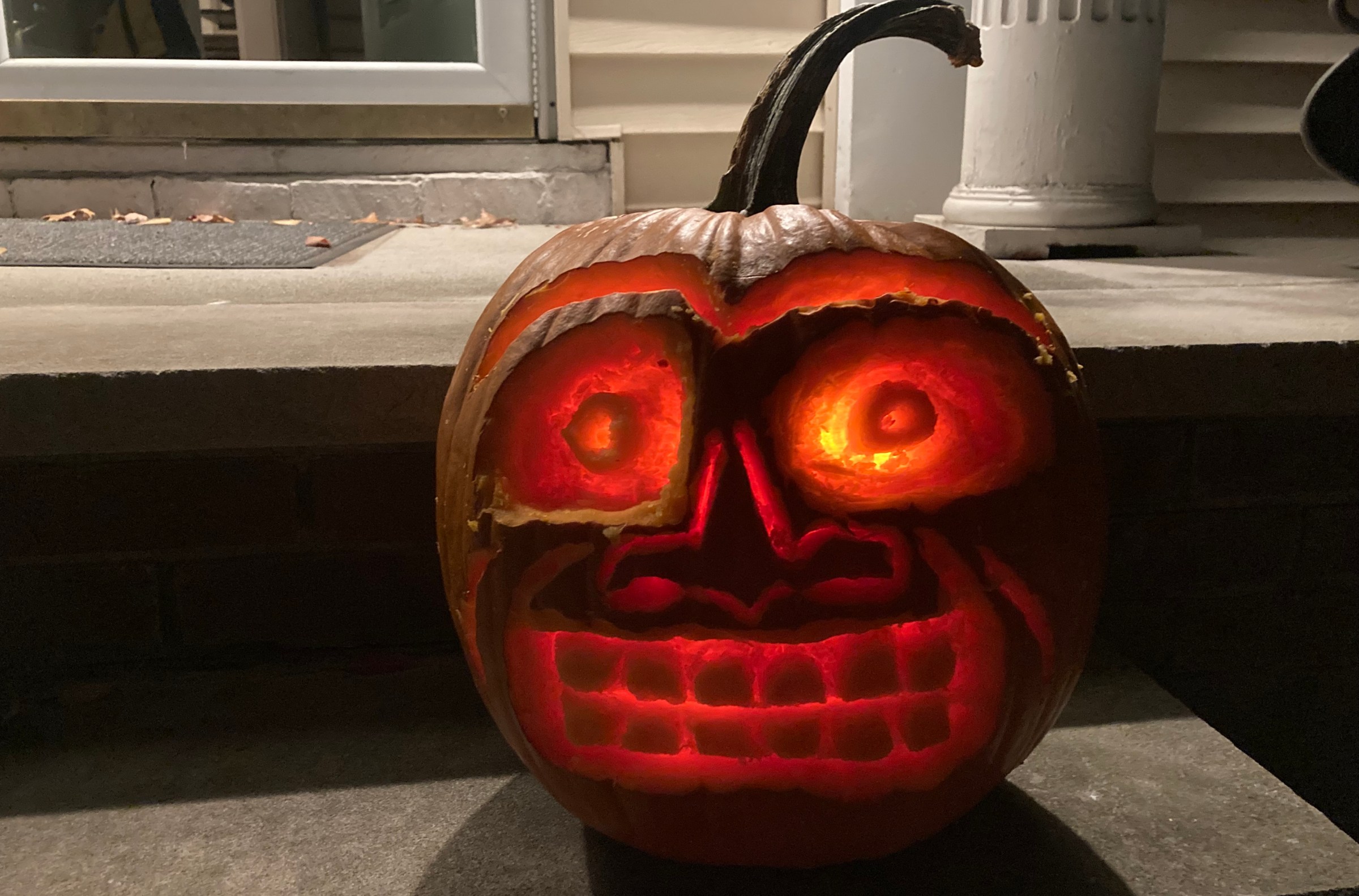 A jack-o-lantern with crazy eyes, a connecting unibrow, and a horrible grimace etched into his face. 