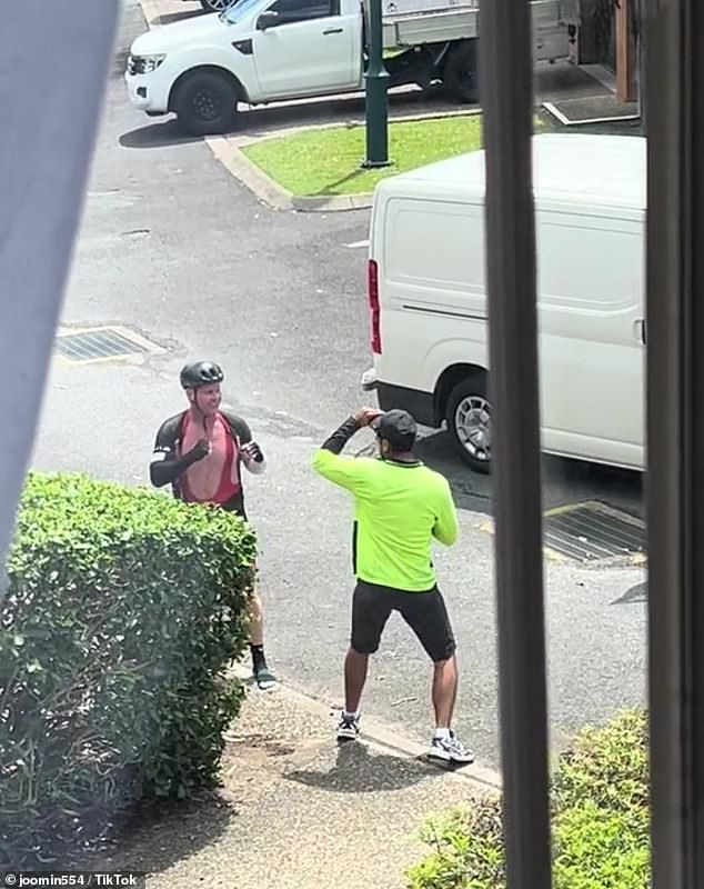 Wild footage shows a tense exchange between a cyclist and a postman as the pair exchange blows in the street