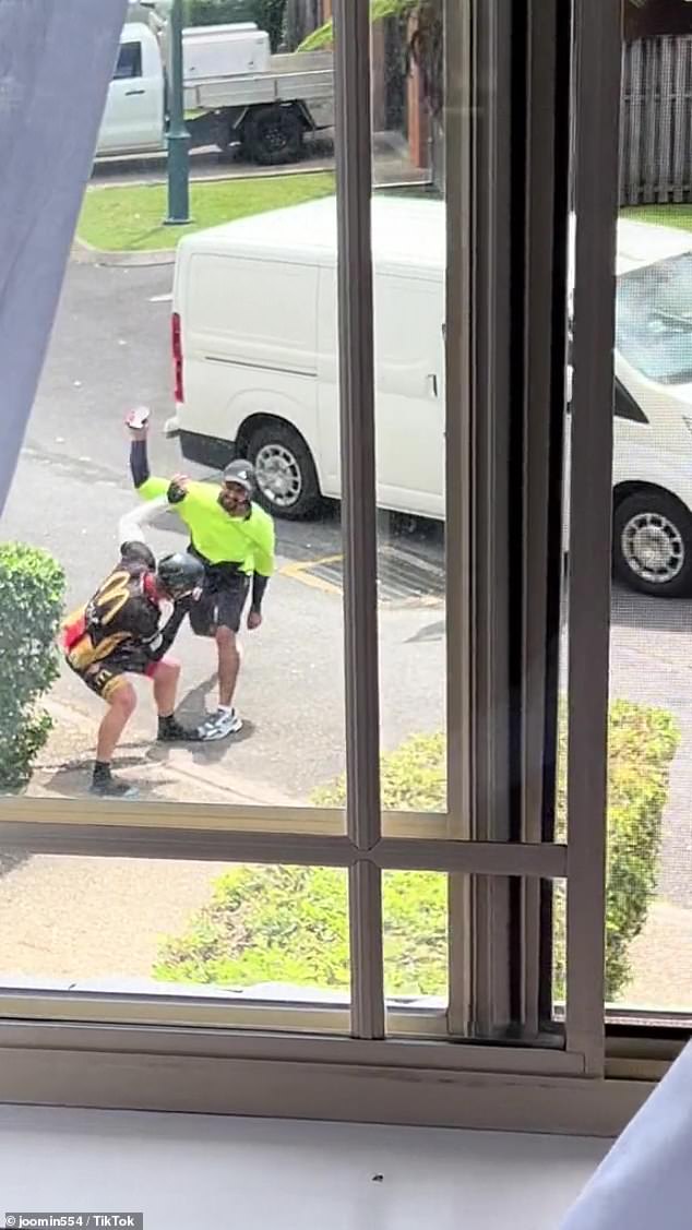 The cyclist and the postman continued to exchange blows, with the postman at one point throwing his scanner at the man before finally admitting defeat (pictured)