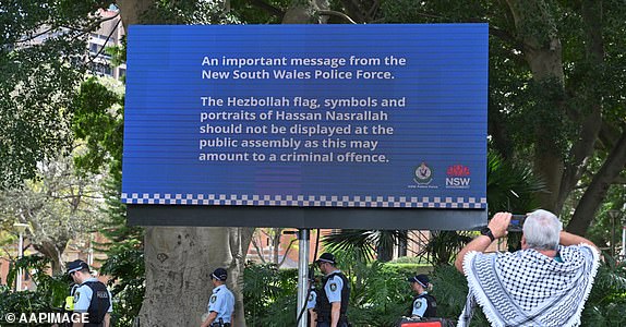 A sign and police are seen at a Pro-Palestine rally in Sydney, Sunday, October 6, 2024. Rallies and vigils in multiple cities over the weekend mark the anniversary of the October 7 attacks in Israel. (AAP Image/Mick Tsikas) NO ARCHIVING