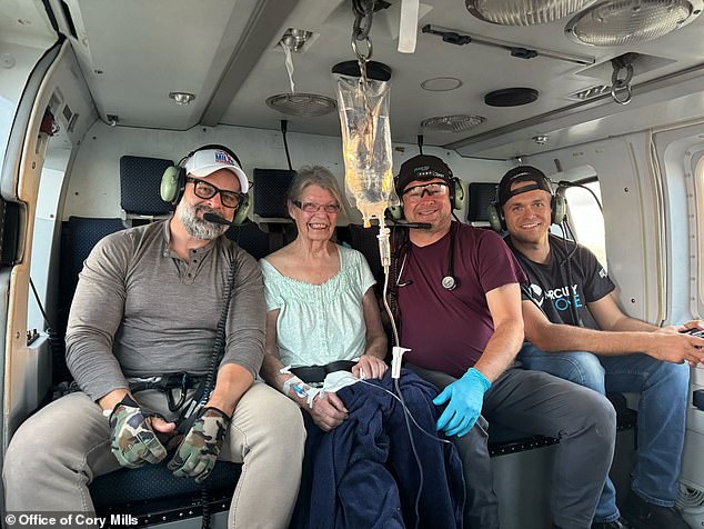 Rep. Cory Mills, R-Fla., (L) sits next to a smiling woman who was helped during his Hurricane Helene relief effort in North Carolina. The woman could not get help and showed signs of illness, Mills said