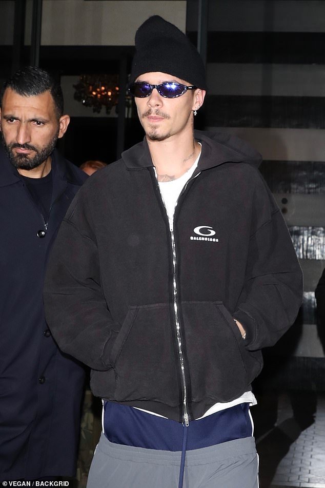 Romeo Beckham, 22, looked grungy in bell-bottom trousers and sunglasses as he celebrated his Balenciaga catwalk debut with dinner in Paris on Monday