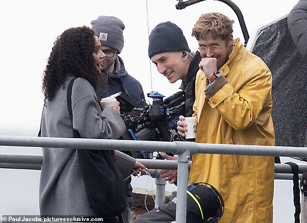 The Barbie actor braved the elements in a yellow raincoat for the stormy seaside scenes