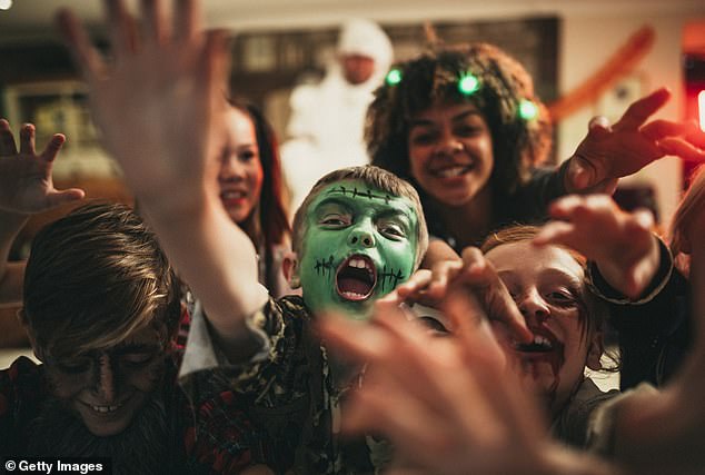 Enthusiastic trick or treaters reaching for candy (stock image)