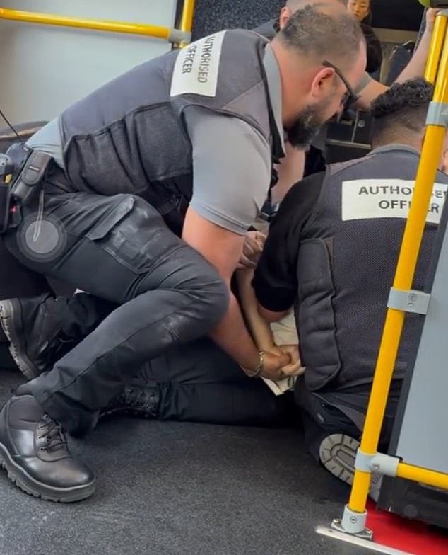 Shocked passengers on a Melbourne bus captured the moment ticket inspectors pinned a man to the ground after he allegedly attacked a worker (pictured)