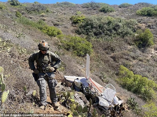 A Los Angeles County sheriff's investigator inspects the plane crash site on Catalina Island