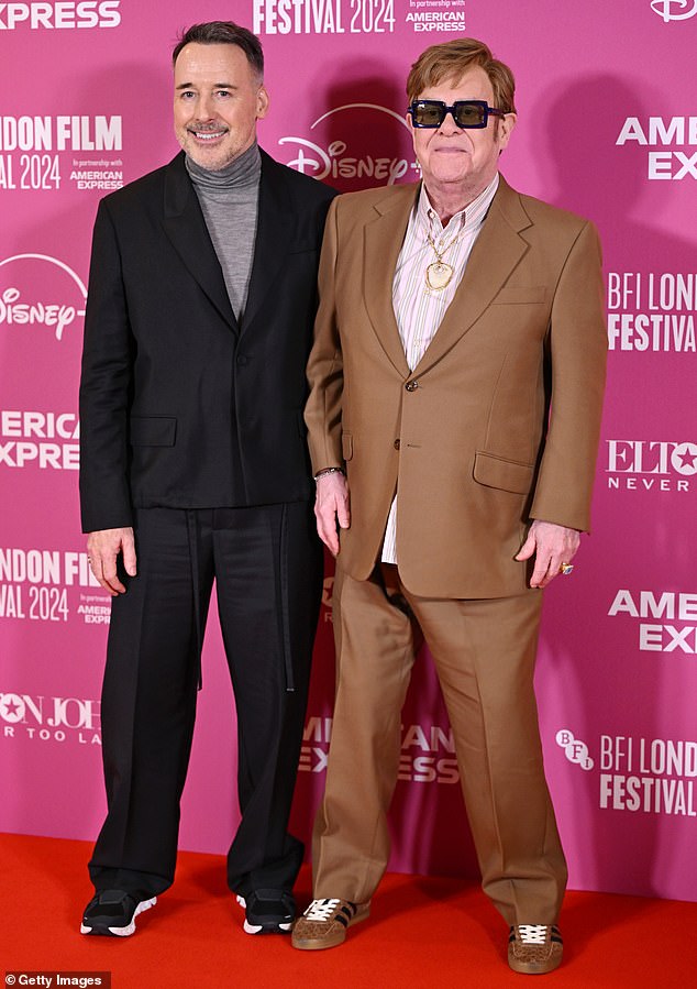 The musician was proudly supported by his husband David Furnish (pictured) and godson Damian Hurley as they graced the red carpet at The Royal Festival Hall