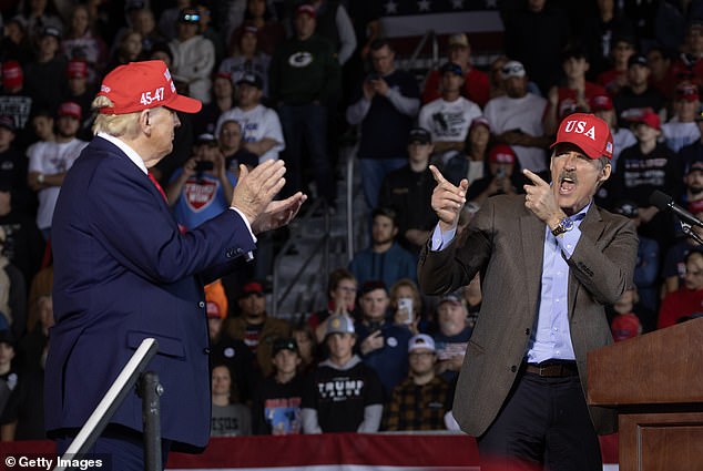 Republican presidential candidate, former President Donald Trump, listens as GOP candidate for U.S. Senate for Wisconsin Eric Hovde speaks during a rally at Dodge County Airport on October 6, 2024 in Juneau, Wisconsin. Cook Political Report indicated that Hovde has improved in his race