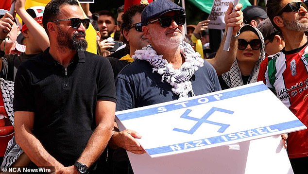 Alan Yazbek held up a sign with a swastika. Photo: NewsWire / Damian Shaw.