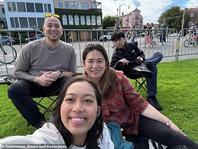 Millicent “Mia” DeGuzman, center, takes a selfie with her family