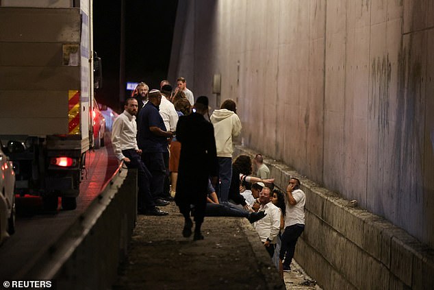 People take shelter during an air raid siren in Israel on Tuesday