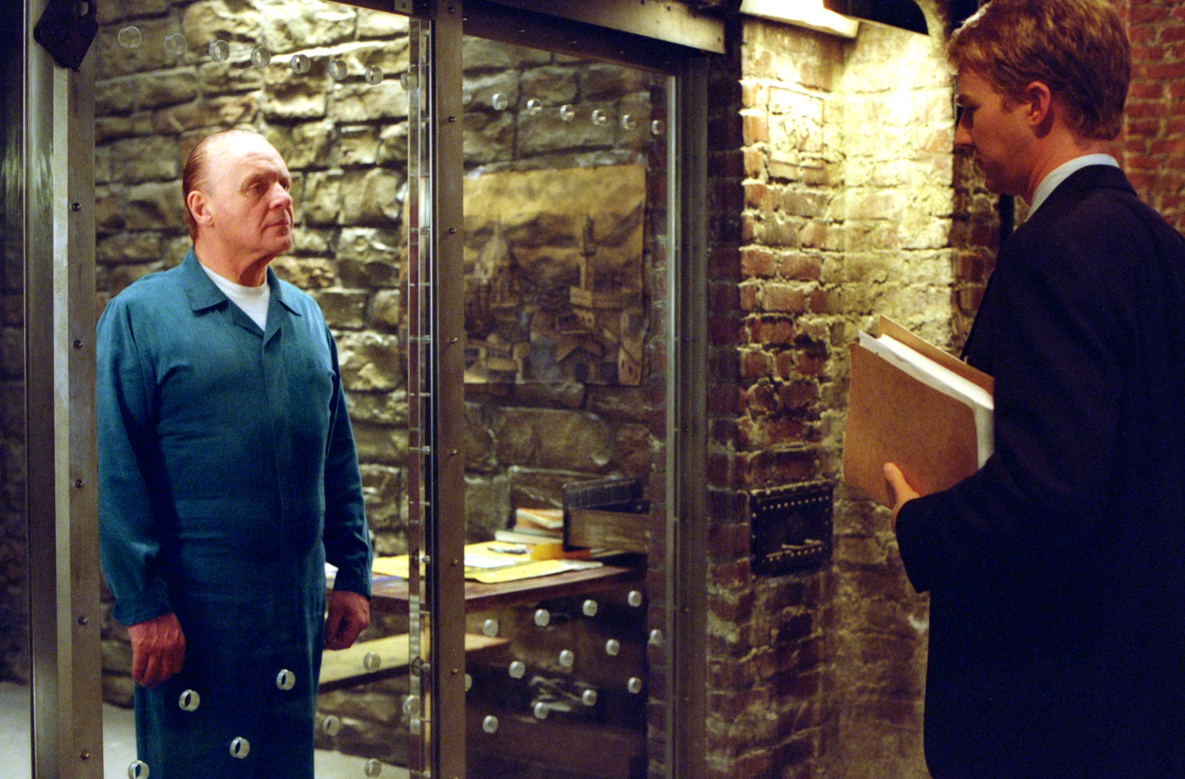 Anthony Hopkins as Doctor Hannibal Lecter and Edward Norton as Will Graham come face to face in Red Dragon with Hopkins behind the class in Hannibal Lecter's iconic prison cell