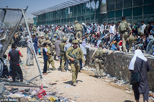 Soldiers help Afghans evacuate the country in August 2021, as the Taliban swept through the province after provinces took control