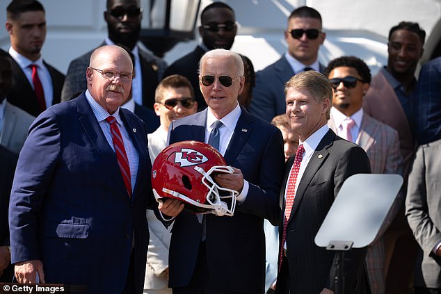 Kansas City Chiefs coach Andy Reid (L) and CEO Clark Hunt (R) present a team helmet to U.S. President Joe Biden during an event on the South Lawn of the White House on May 31