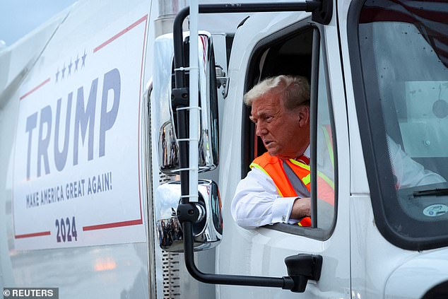 Republican presidential candidate and former US President Donald Trump sits in a garbage truck while wearing a safety vest on the tarmac at Green Bay Austin Straubel International Airport in Green Bay, Wisconsin on Wednesday