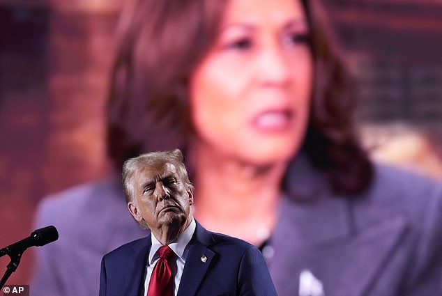 Trump watches as a video featuring Democratic presidential candidate Kamala Harris plays during a campaign event on Friday in Detroit