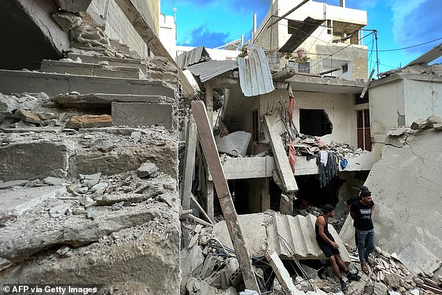 Residents inspect damage after a nighttime Israeli airstrike on the Ain al-Helweh camp for Palestinian refugees on the outskirts of the southern port city of Sidon early October 1, 2024