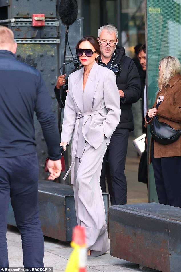 The former Spice Girl looked stunning in a chic gray suit as she was followed down the street by a camera crew