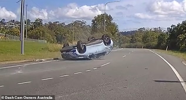 The impact sent the car flying through the air before coming to rest upside down (pictured) and resulting in one passenger being taken to hospital with minor neck injuries