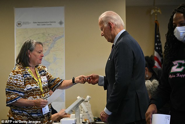 Biden hands over his driver's license as proof of identity while voting early in New Castle, Delaware