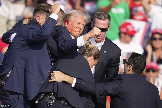 Republican presidential candidate, former President Donald Trump, is helped off stage during a campaign event in Butler, Pennsylvania.