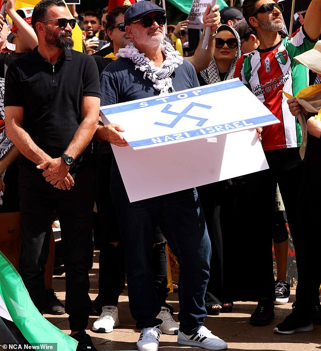 Al Yazbek pictured with a Nazi swastika atop an Israeli flag during a protest in Hyde Park in Sydney's CBD