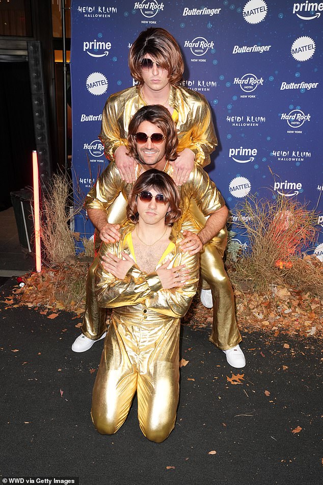 The artist was in good company that evening when he engaged 39-year-old Thom Evans. [centre] was also in attendance, with the rugby ace wearing a gold ensemble and brunette wig as he posed with friends Diego Rodriguez and Tom Francis