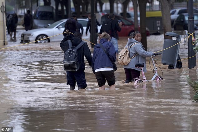 People walk through flooded streets in Valencia