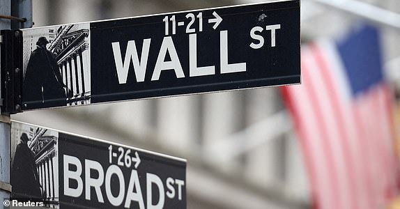 FILE PHOTO: A Wall Street sign hangs in front of an American flag outside the New York Stock Exchange (NYSE) before the Federal Reserve announcement in New York City, US, September 18, 2024. REUTERS/Andrew Kelly/File Photo