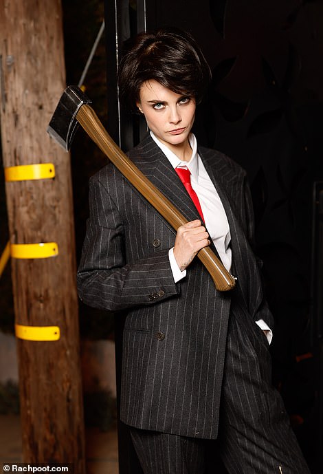 Model Cara, 32, carried an ax and wore a suit as she transformed into American Psycho's Christian Bale as she gave a scary look to the camera