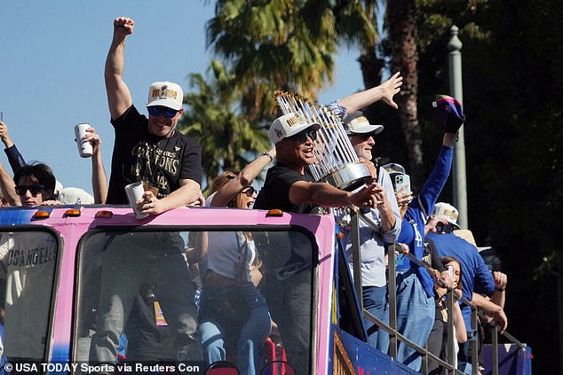 Los Angeles Dodgers manager Dave Roberts holds the World Series trophy during the parade