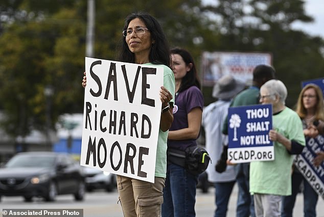 Protesters watch outside the prison ahead of the scheduled execution of Richard Moore, Friday, November 1, 2024