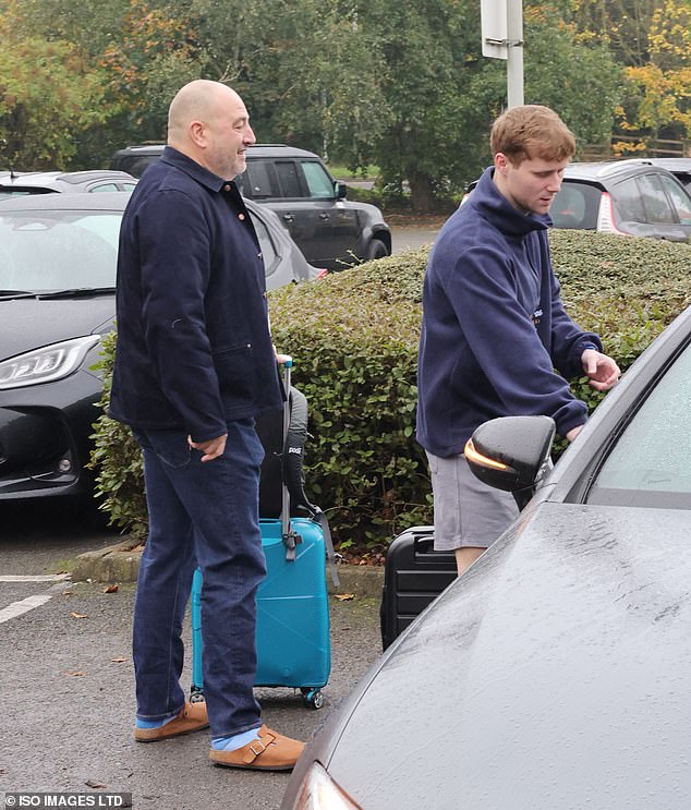 The radio host wore a pair of blue socks and brown Birkenstocks and wheeled his blue suitcase, while Jamie braved the cold in gray shorts.