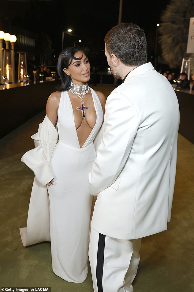 Elsewhere, Kim Kardashian turned heads in a daring white plunging dress as she chatted with designer Sabato De Sarno