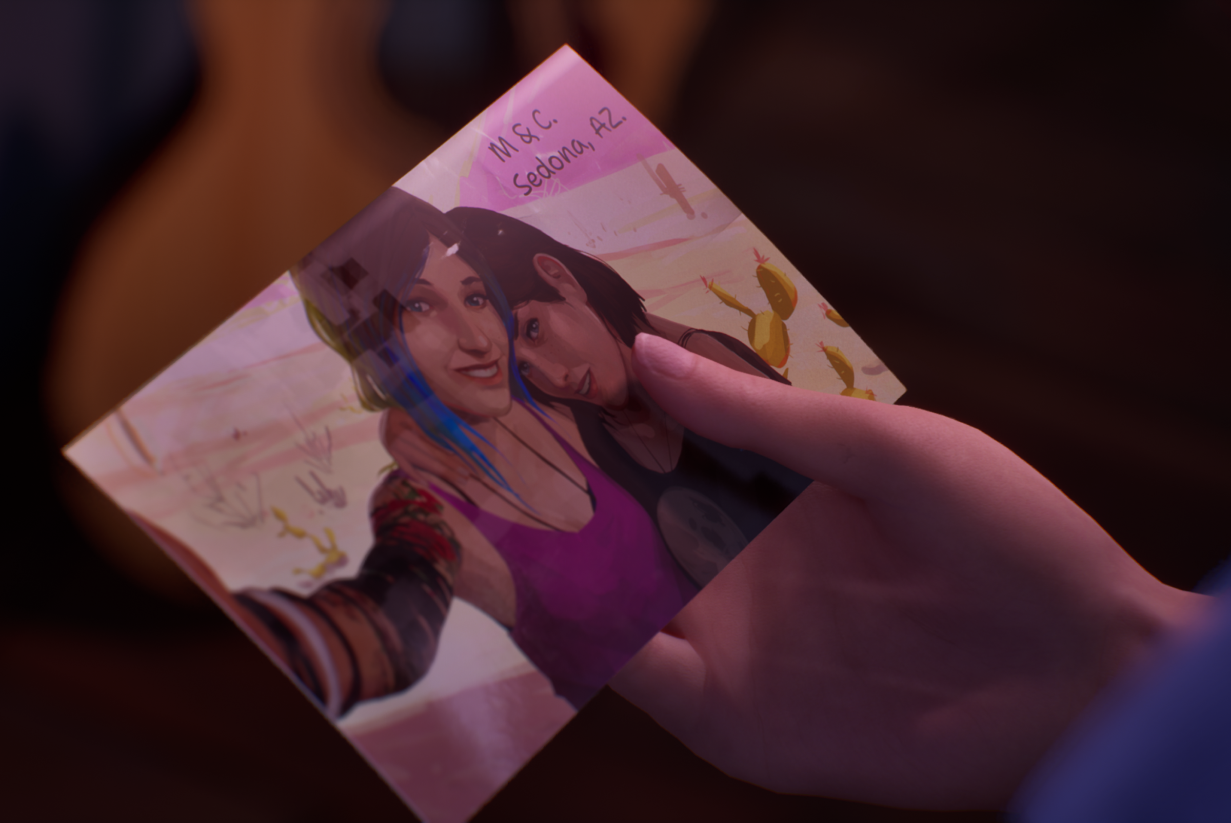 A zoomed-in look at a character's hand holding a photo of two people smiling and posing for a selfie in Life Is Strange: Double Exposure