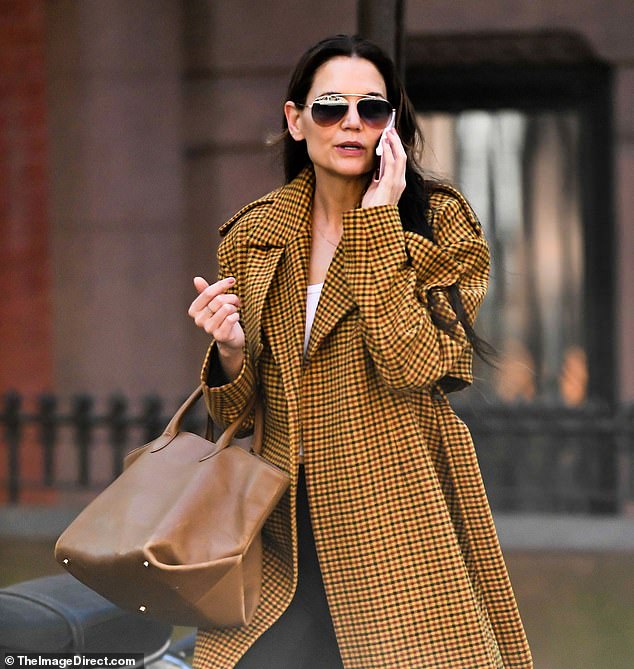 The 45-year-old Dawson's Creek star wore a stunning floor-length brown plaid coat over a simple outfit of a white T-shirt and black leggings.