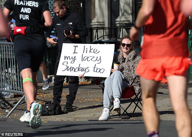 A spectator holds up a sign that reads 