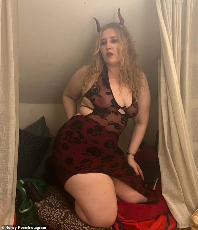 The podcast host left little to the imagination in a sheer cut-out dress with black lace flowers, a maroon underskirt with a thigh-high slit and a pair of devil horns